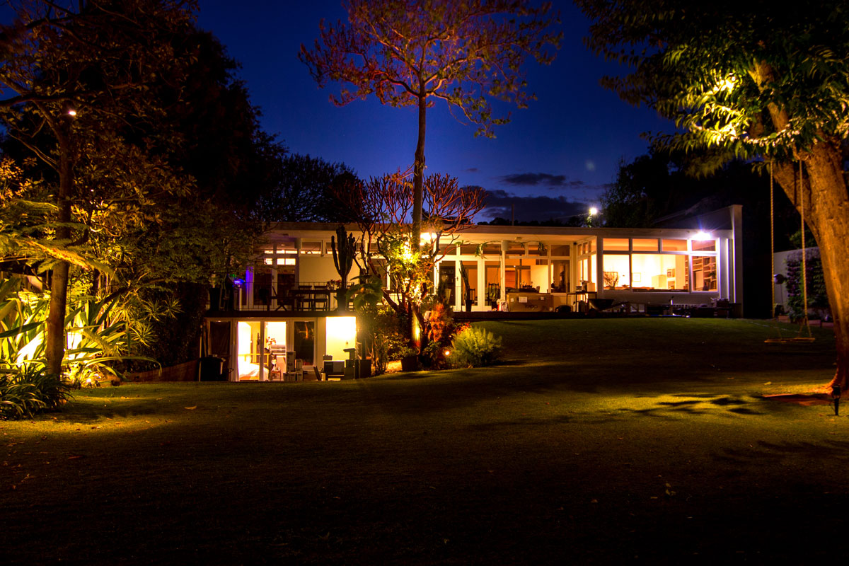 beautiful large backyard lit up at night by warm white garden lights