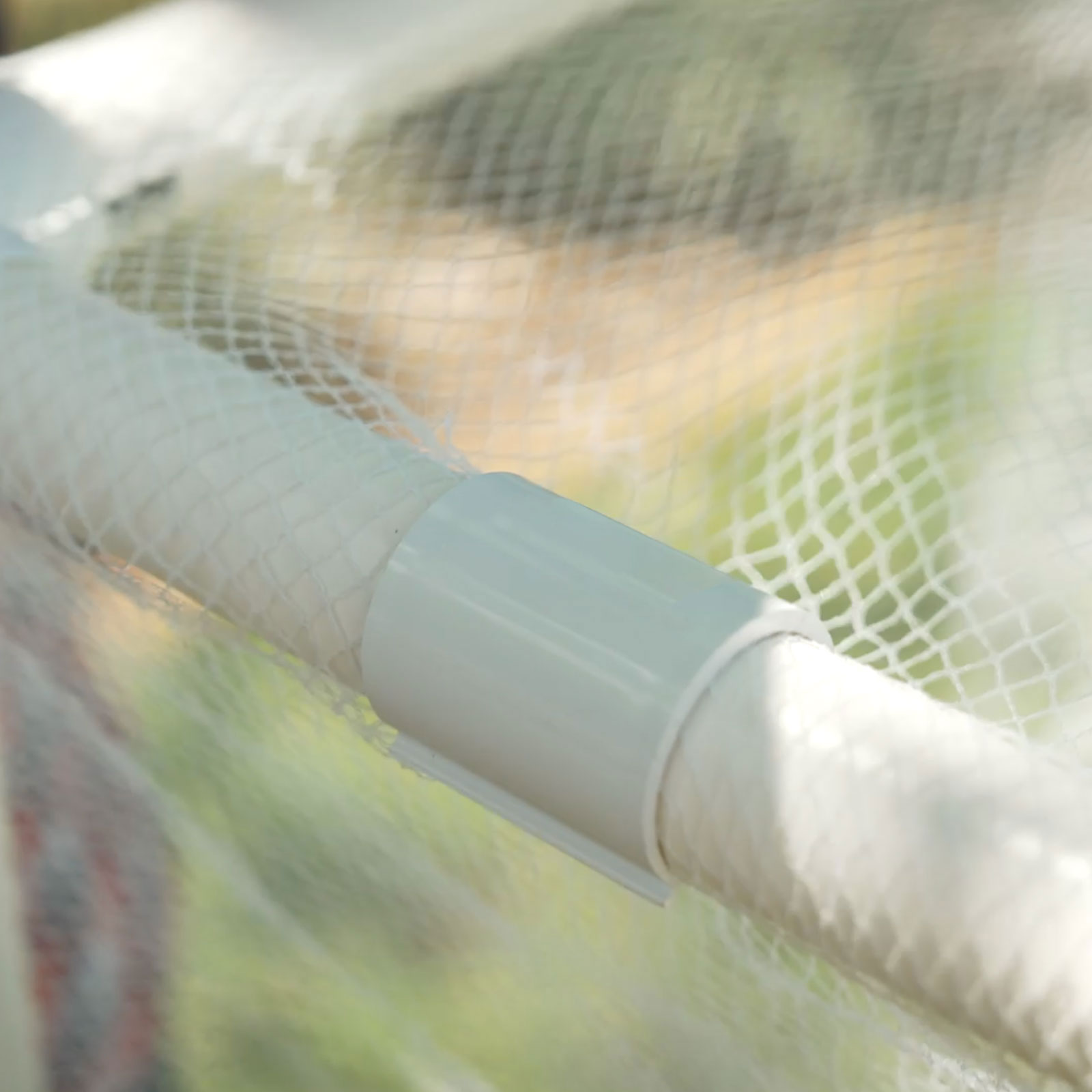 Ezyfit snap-on clamp fitted over frame and netting. Holding garden netting firmly in place over PVC pipe frame.