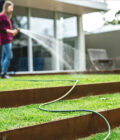 Watering a terraced lawn with a Yardmate green garden hose and Holman multi function spray gun.