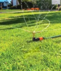 3 Arm Metal Sprinkler watering lawn 3 Arm Metal Sprinkler watering lawn
